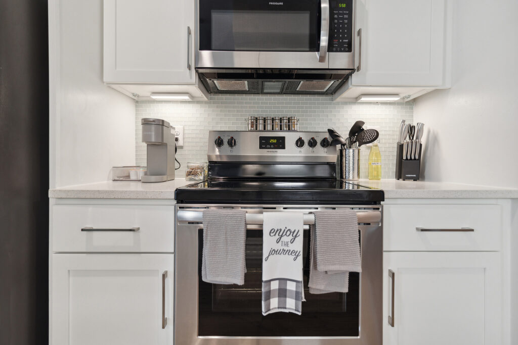 A stove with a microwave above it in the kitchen.