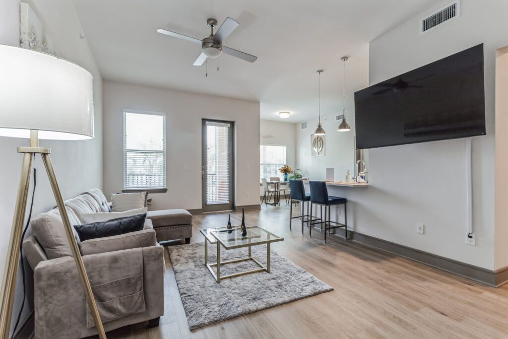 A living room with a couch, chair and television.