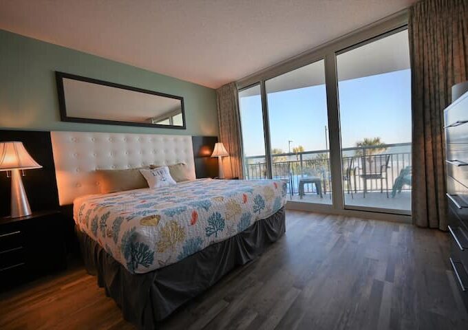 A bedroom with a large bed and balcony