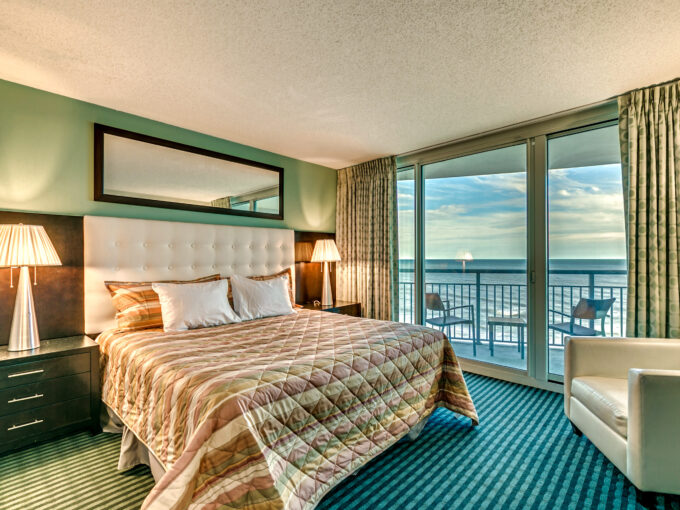 A bedroom with a large bed and balcony