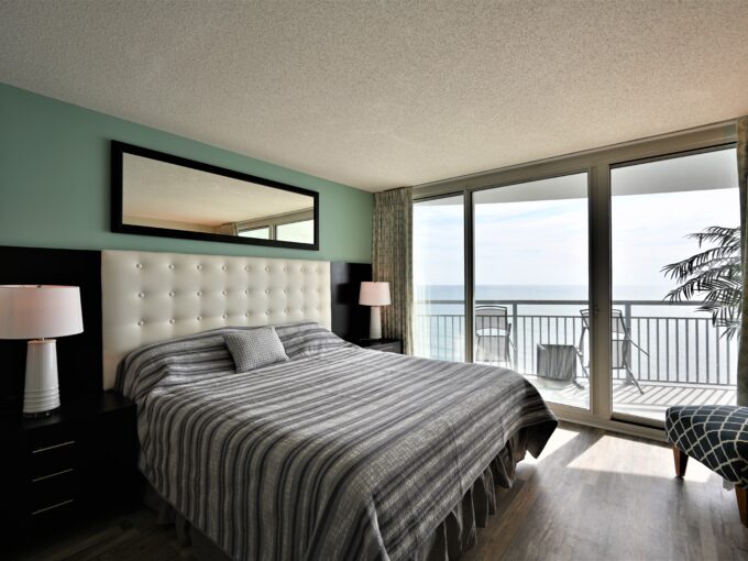 A bedroom with a large bed and a balcony