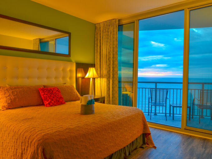 A bedroom with a view of the ocean and a bed.