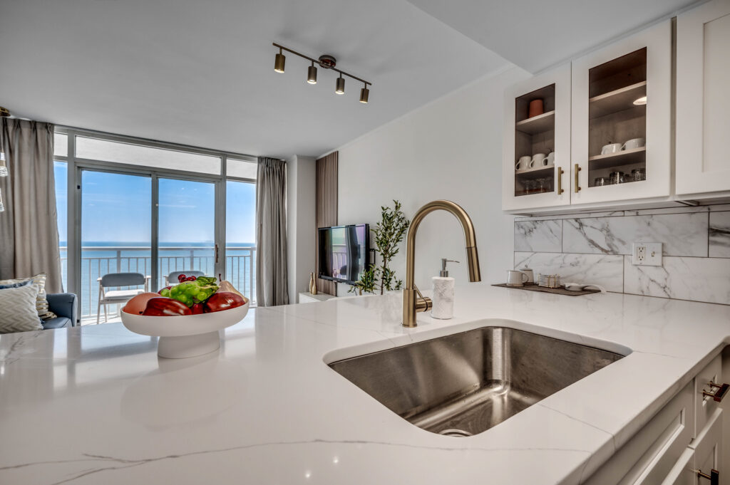 A kitchen with a sink and a bowl of fruit