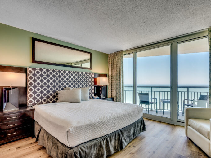 A bedroom with a view of the ocean and a bed.