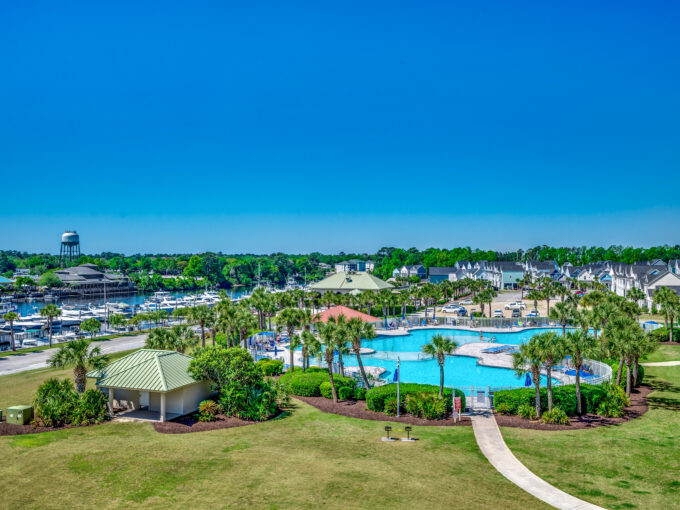 A large pool with palm trees and a blue sky