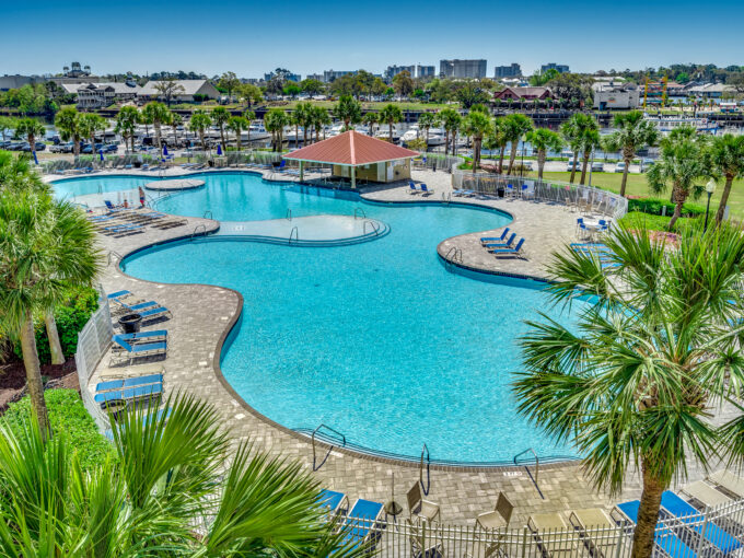 A pool with many chairs and umbrellas in it