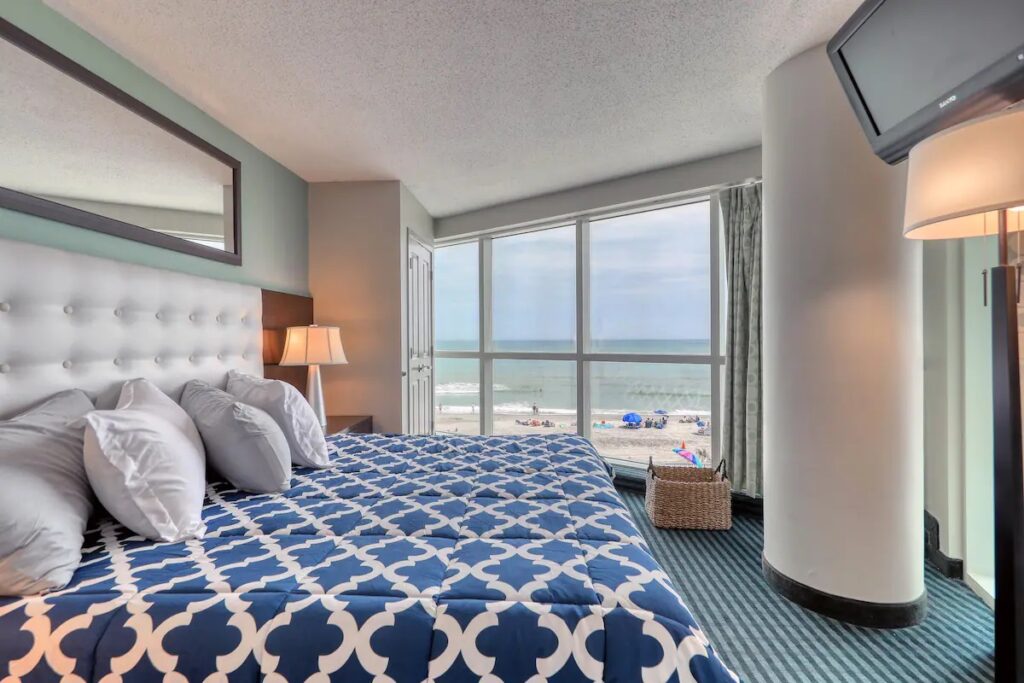 A bedroom with a view of the ocean and a bed.