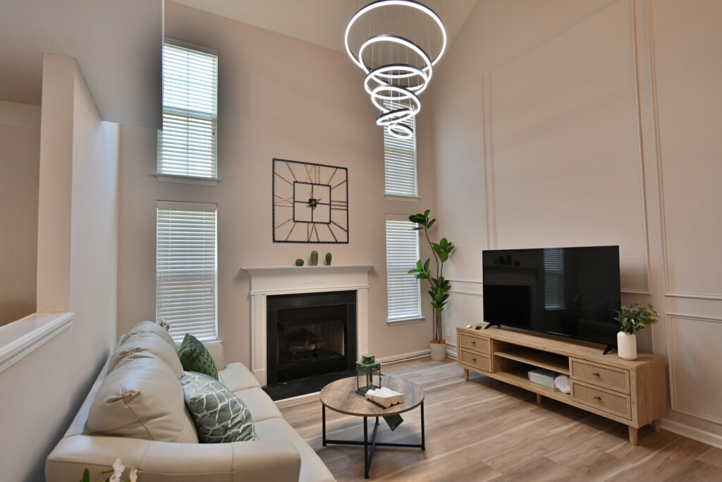 A living room with a couch, television and fireplace.