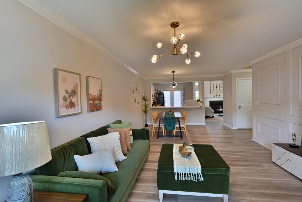 A living room with green furniture and white walls.