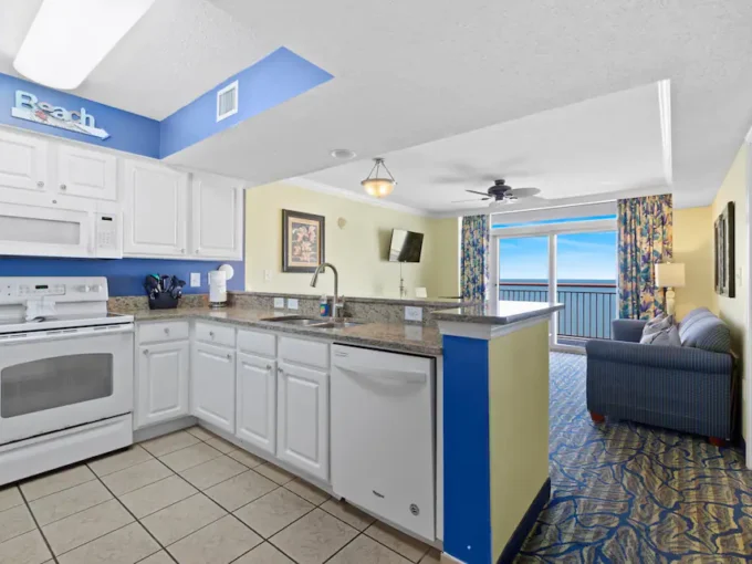 A kitchen with white cabinets and blue walls.