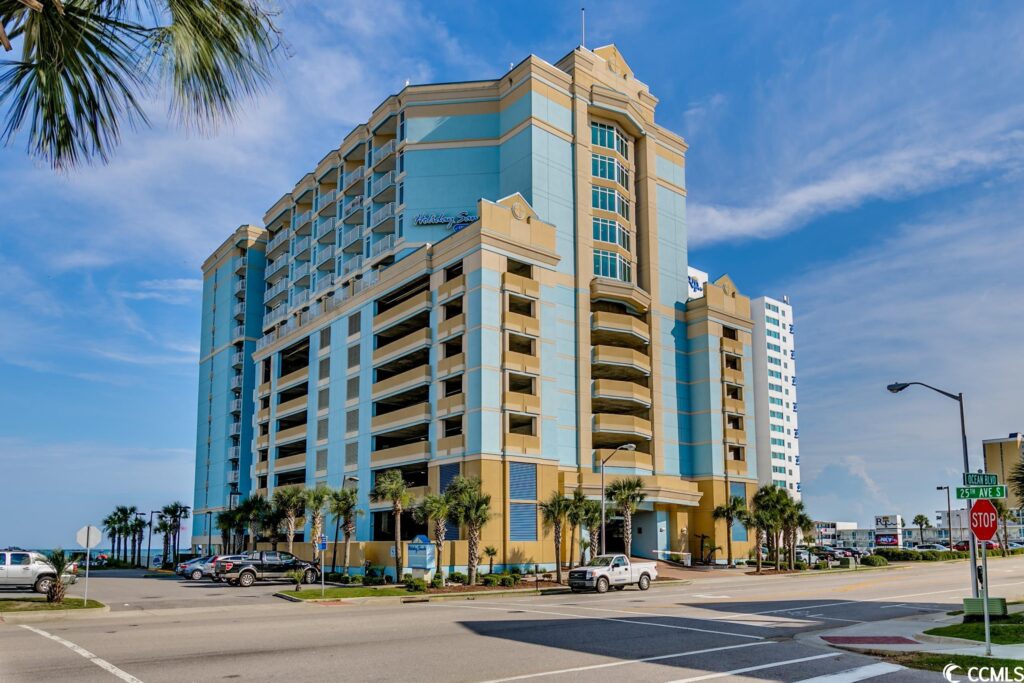 A large building with cars parked on the side of it.